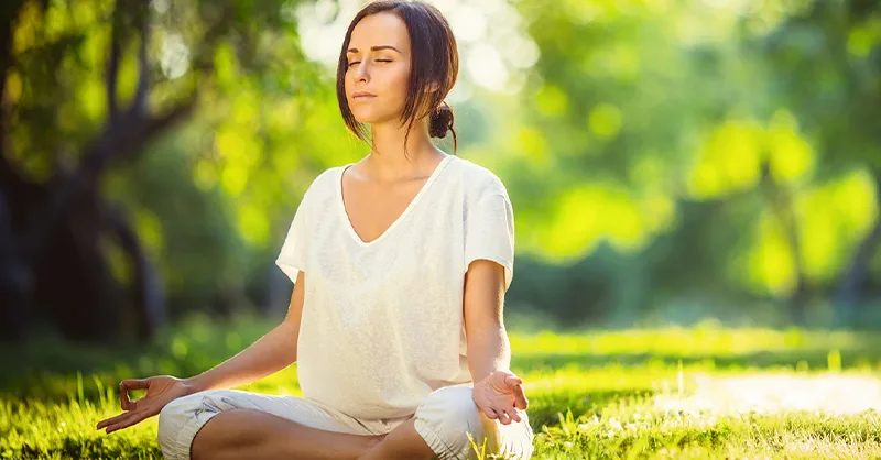 Méditation en pleine nature d'une personne, une femme pour gérer le stress.