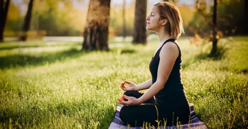 Image d'une personne, une femme dans la nature faisant de la  méditation.